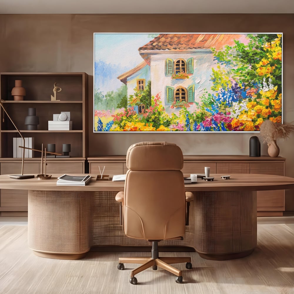 Tablou canvas cu pictura cu casa alba si flori, in rama de aluminiu argintiu, pe perete intr-un birou